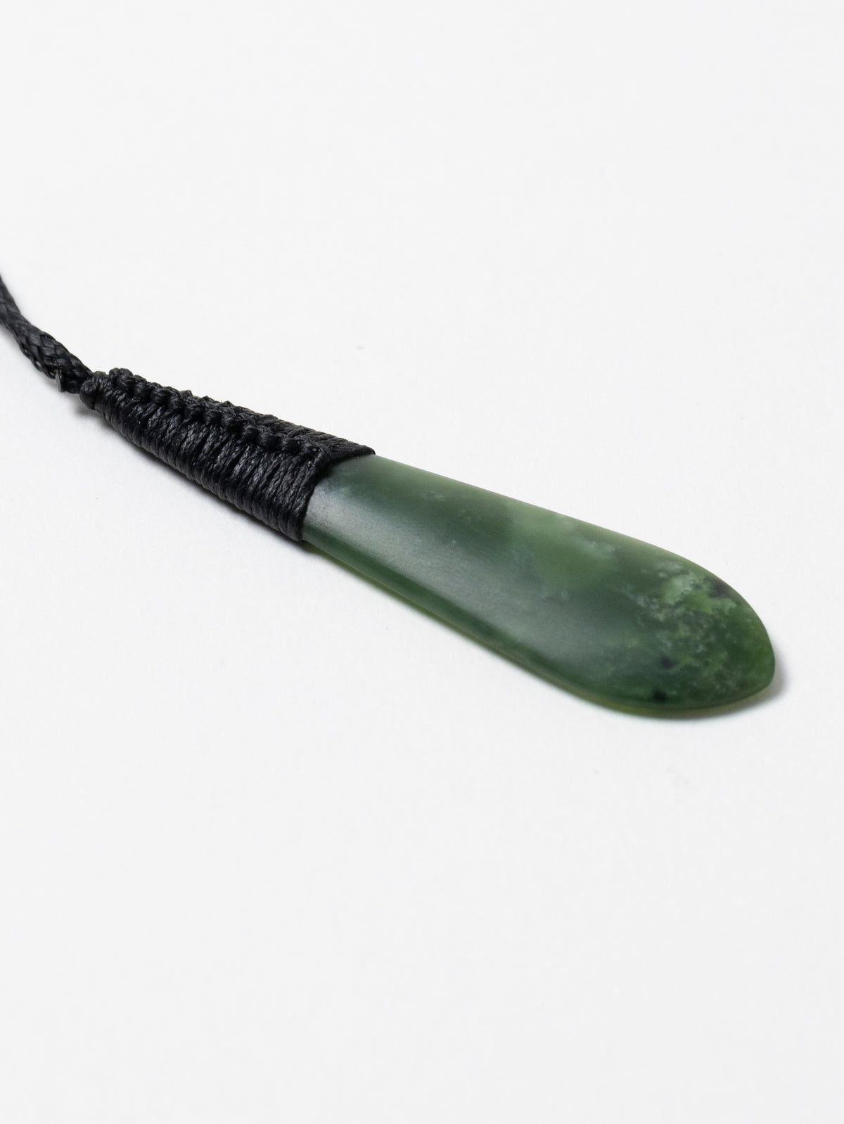 Angled close-up of the Kahurangi pounamu roimata pendant and black binding