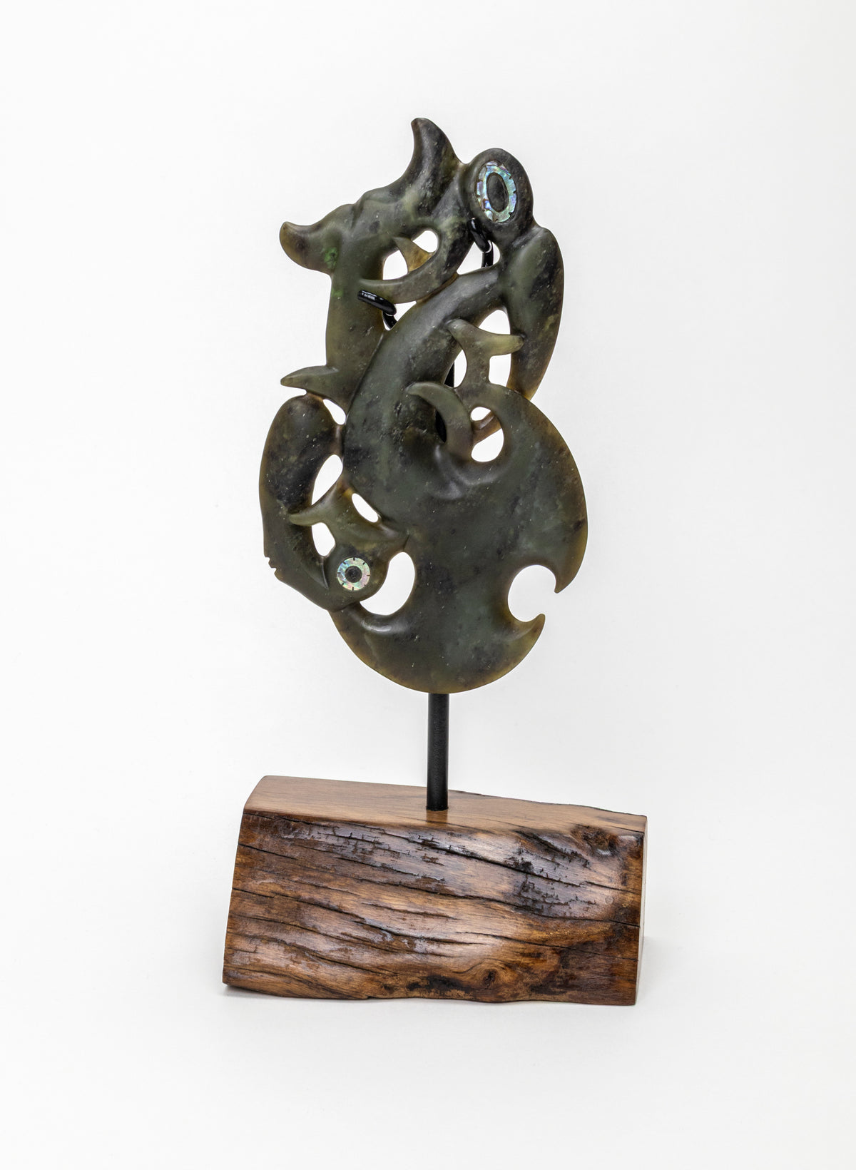 Manaia Pounamu on a Stand, front view of the carving and textured wooden base