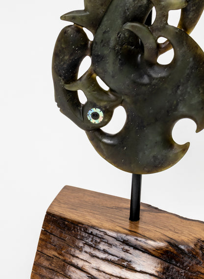 Manaia Pounamu on a Stand, close-up of the lower carving, support rod and wooden base