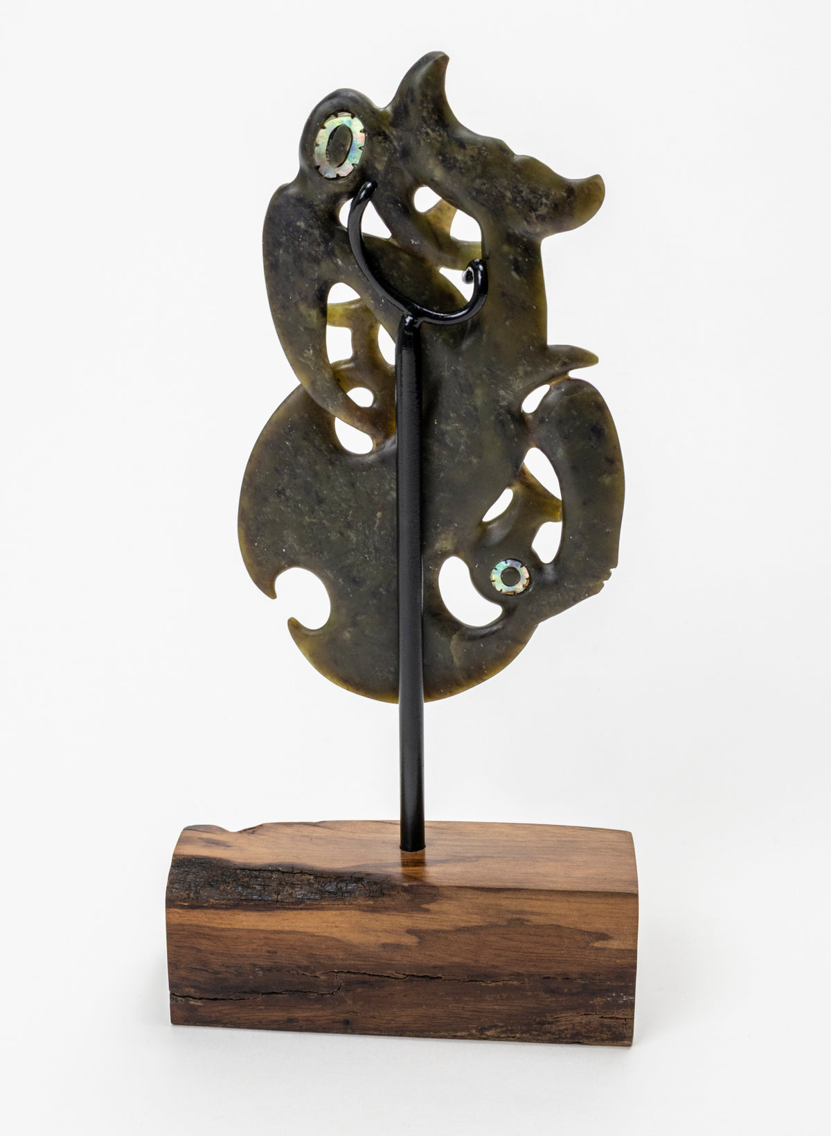 Manaia Pounamu on a Stand, rear view showing the black support rod and wooden base