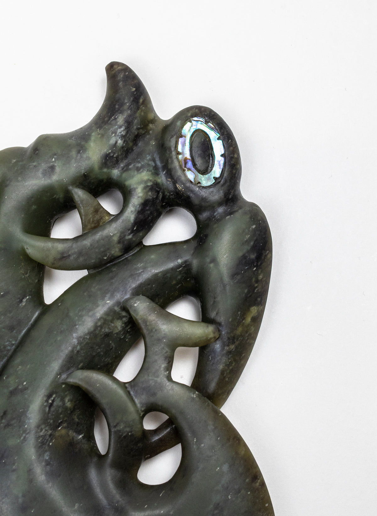 Manaia Pounamu on a Stand, detail of the eye, head and upper carved curves